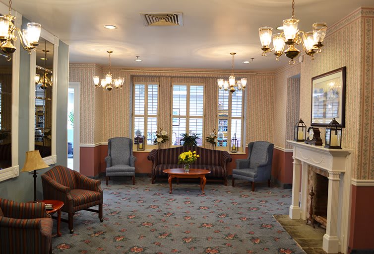 A cozy lobby with elegant chandeliers, comfortable seating, and large windows.