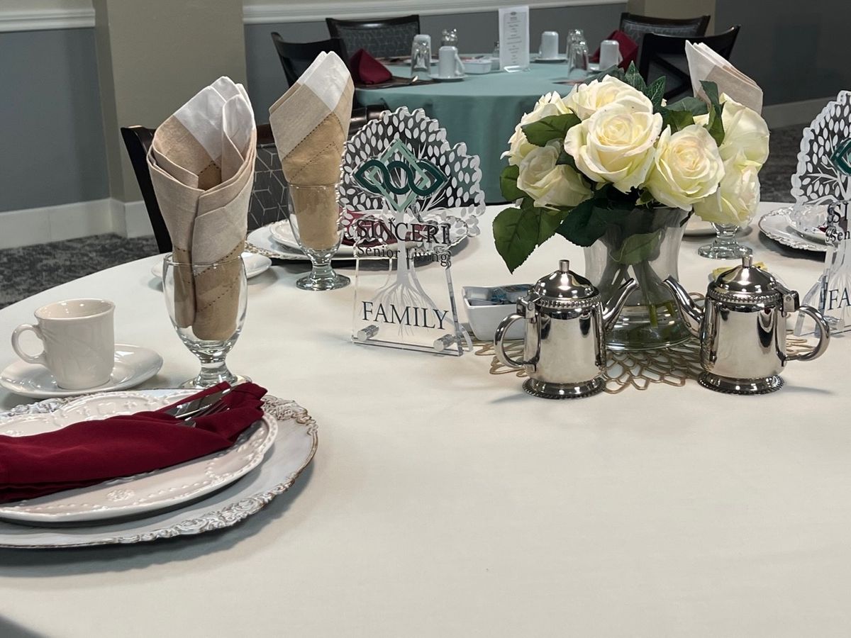 Elegant table setting with folded napkins and a floral centerpiece.