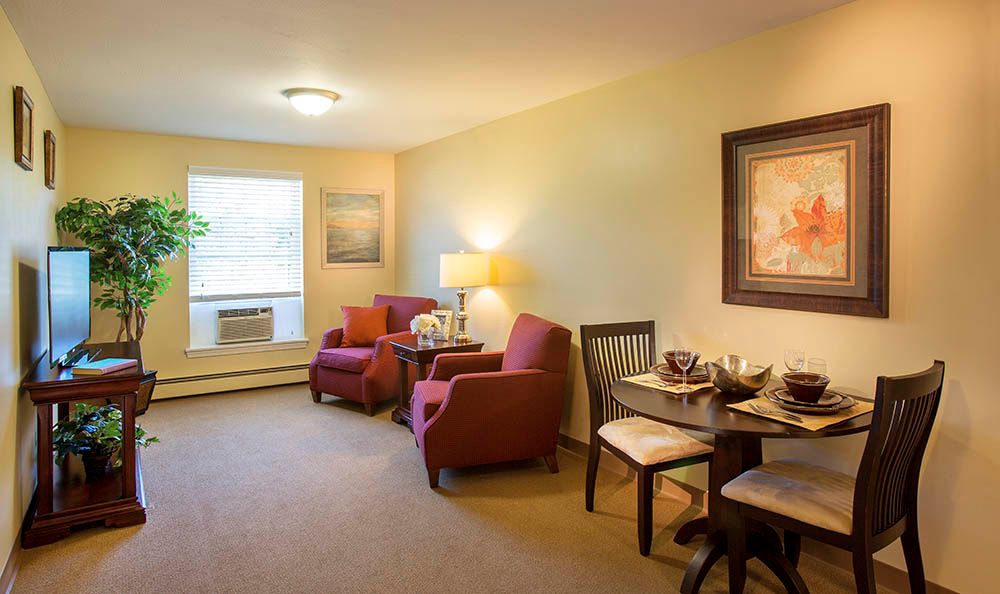 Cozy living room with comfortable chairs and a small dining area.