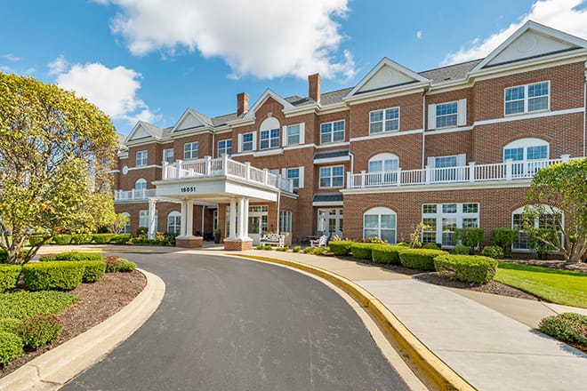 A large residential building with a brick exterior and a welcoming driveway entrance.