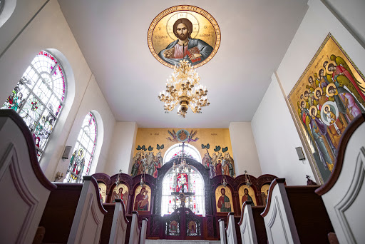 The beautiful interior of a church, showcasing religious icons and an ornate chandelier.