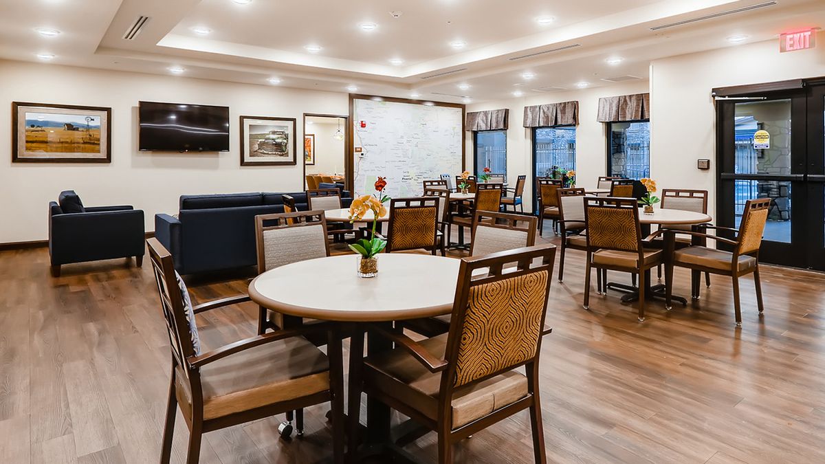 A well-lit dining area with neatly arranged tables and chairs.