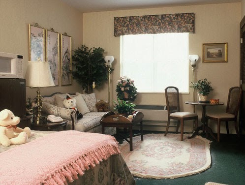 A cozy bedroom featuring elegant decor with a seating area and natural light coming through the window.
