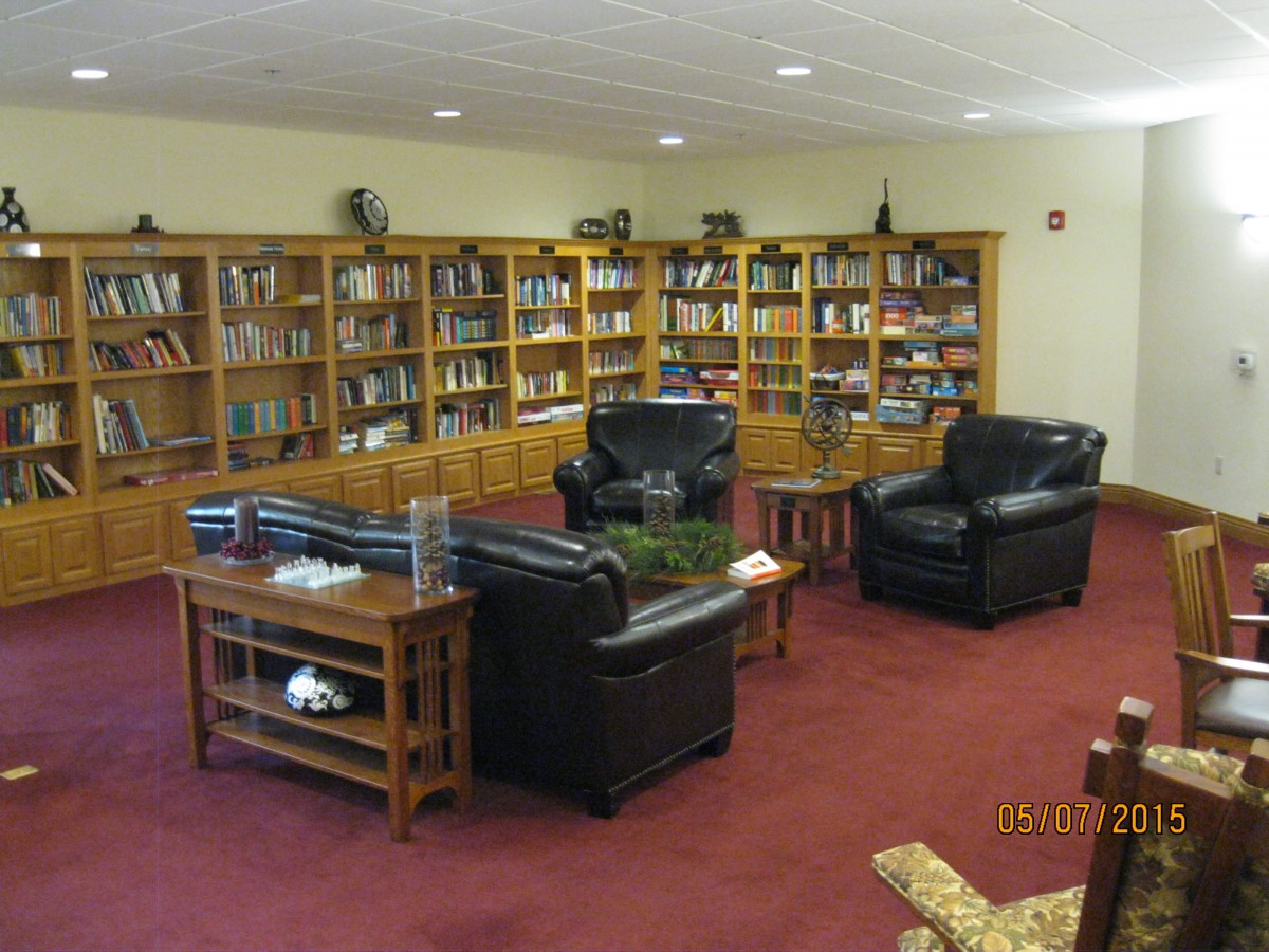 A cozy library corner with leather seating and well-stocked bookshelves.
