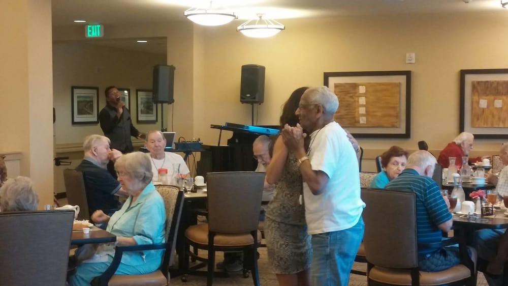 A joyful moment as seniors dance and socialize in a community setting.
