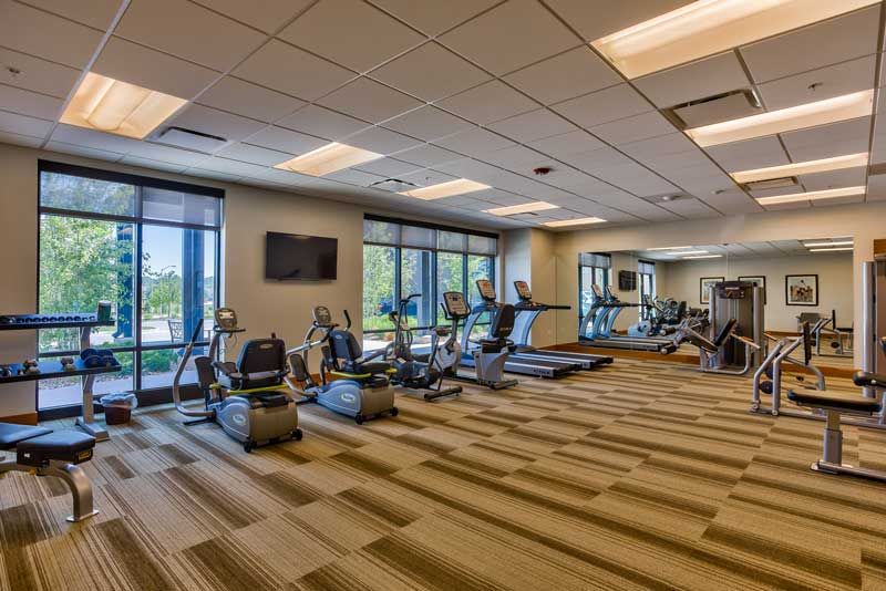 Modern gym with exercise equipment, including treadmills and stationary bikes.