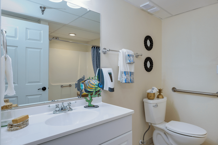 A clean and well-decorated bathroom with a sink, mirror, and toilet.
