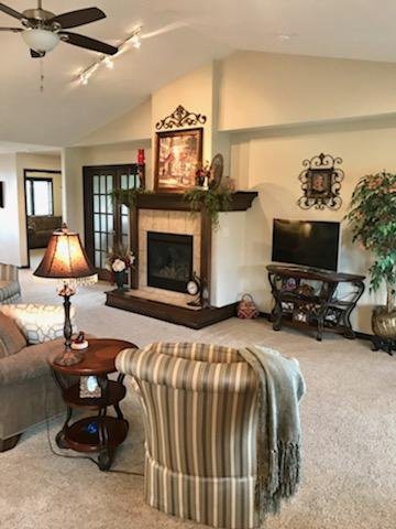 A cozy living room featuring a fireplace, sofa, television, and elegant decor.