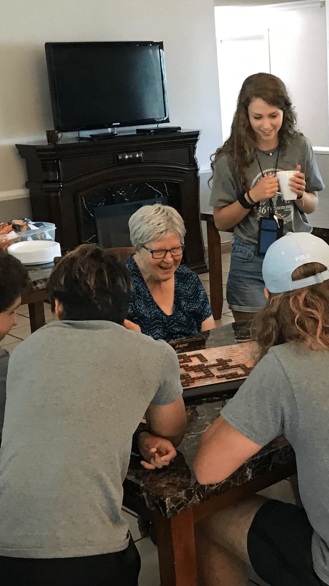 A group of people gathered around a table working on a puzzle together.