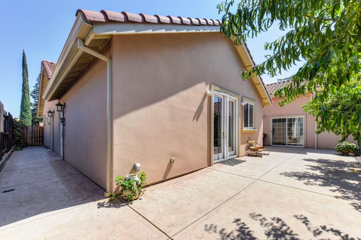 A sunny exterior view of a house with a spacious patio area.