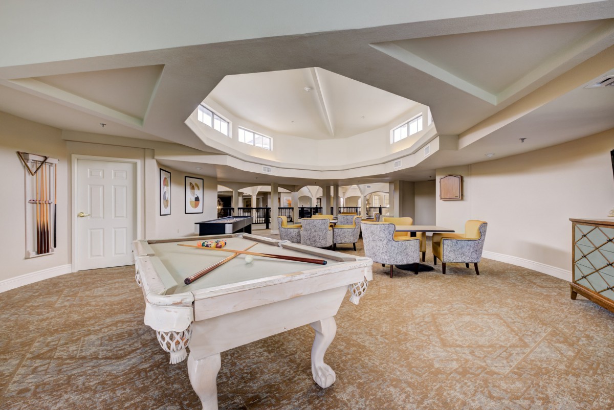 A spacious recreational room featuring a pool table and comfortable seating area.