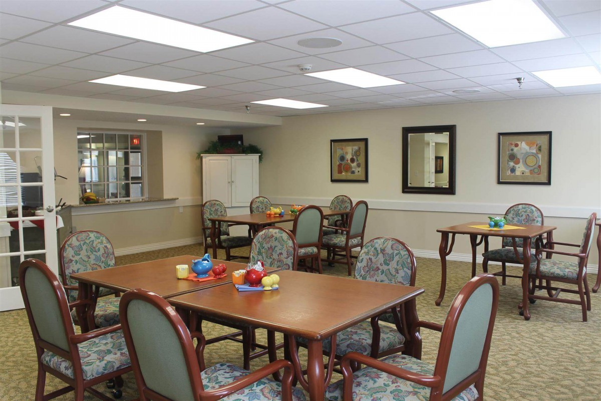 A well-lit dining area with tables and chairs, decorated in a community space setting.