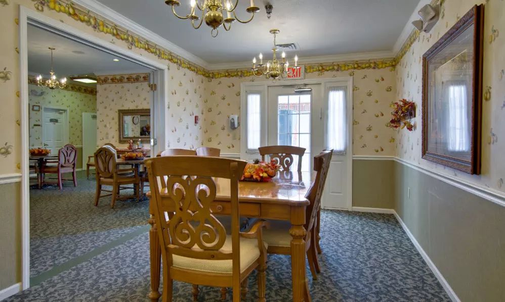 A traditional dining room with wooden furniture and a chandelier.