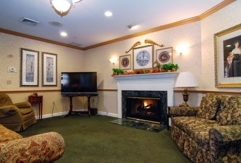 A cozy living room with a fireplace and a television, featuring comfortable seating and warm decor.