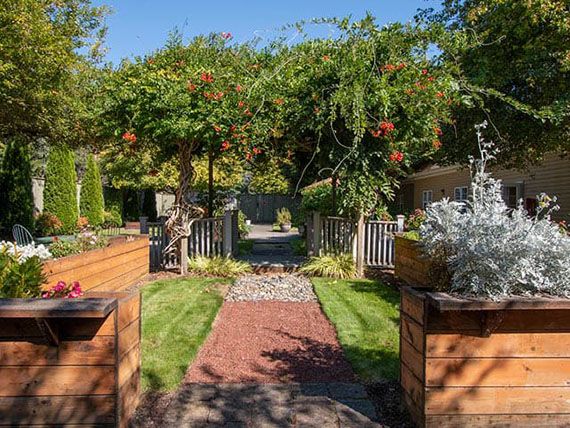 A beautifully landscaped garden with a brick pathway and lush greenery.