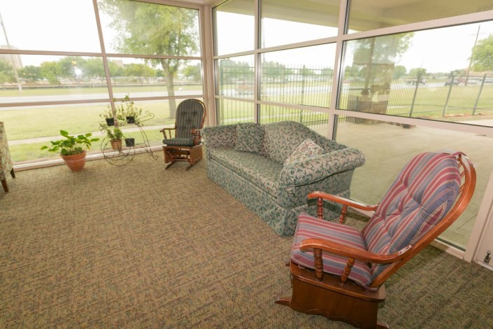 A cozy sitting area with armchairs and a sofa by large windows.