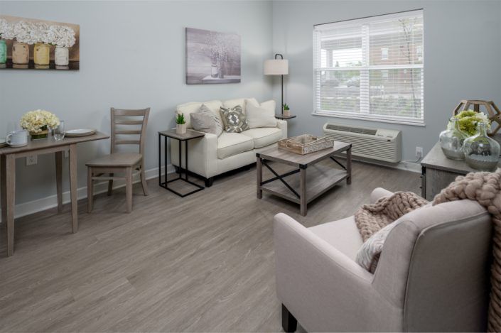 A modern, minimalist living room with a cozy sofa and armchair, complemented by a coffee table and stylish decor.