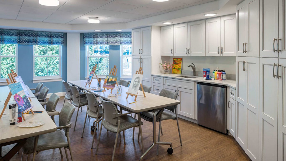 A well-lit kitchen area with art supplies set up on tables.