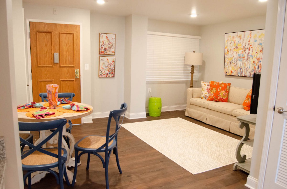 A cozy living room with a small dining area, featuring warm colors and stylish decor.
