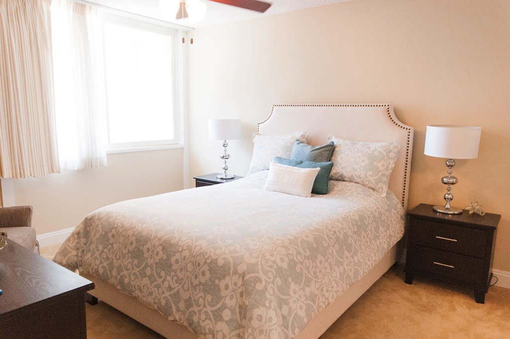 A cozy bedroom with a neatly made bed and soft lighting.