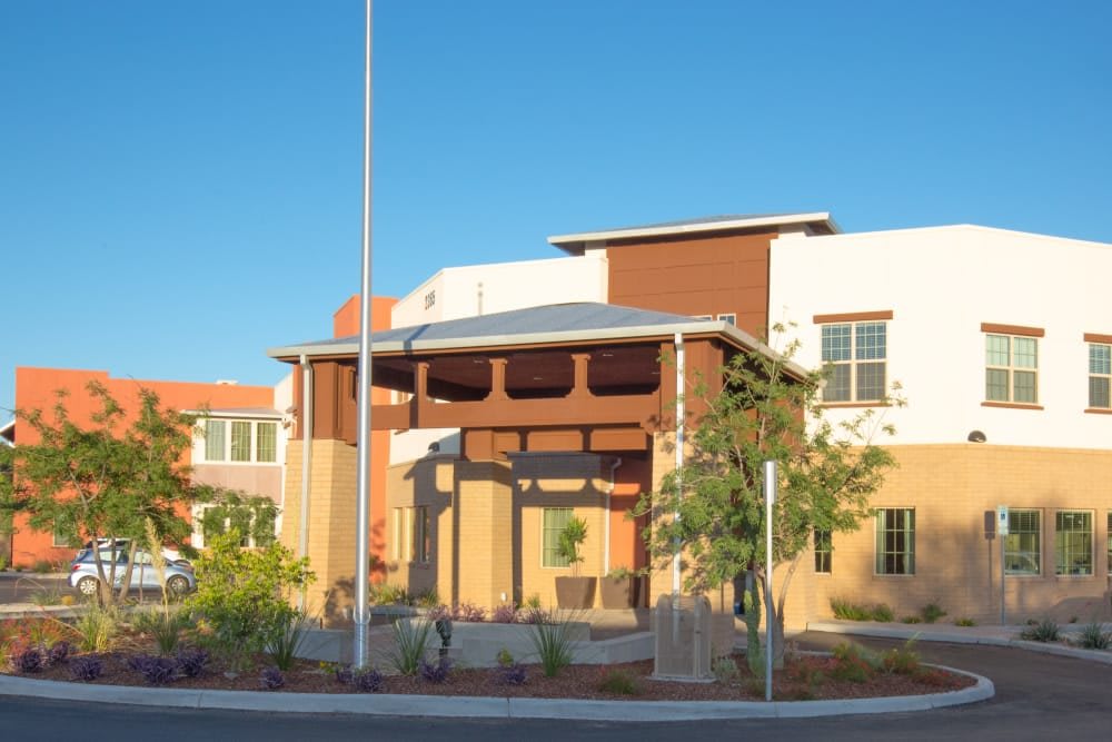 A modern building with landscaping under a clear blue sky.
