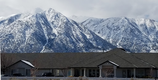 A picturesque view of snow-covered mountains in winter, with a building in the foreground.