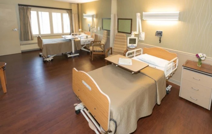 A modern hospital room with medical beds and equipment.