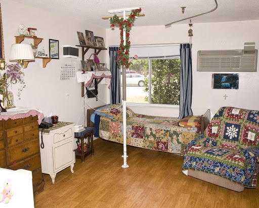 A cozy interior space with a bed, decorative quilts, and a view through the window.