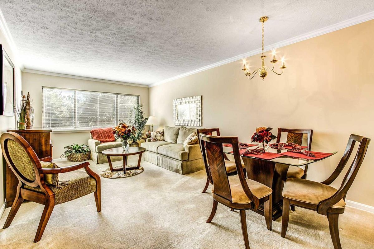 Spacious living and dining area with elegant furniture and bright natural lighting.