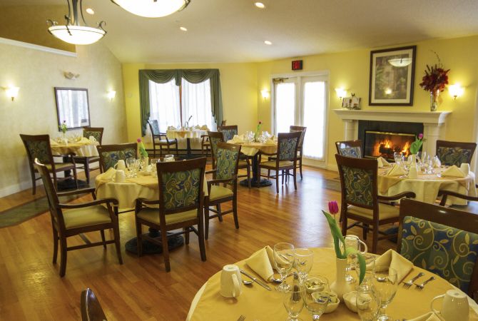 A warmly decorated dining room with elegantly set tables, ready for guests.