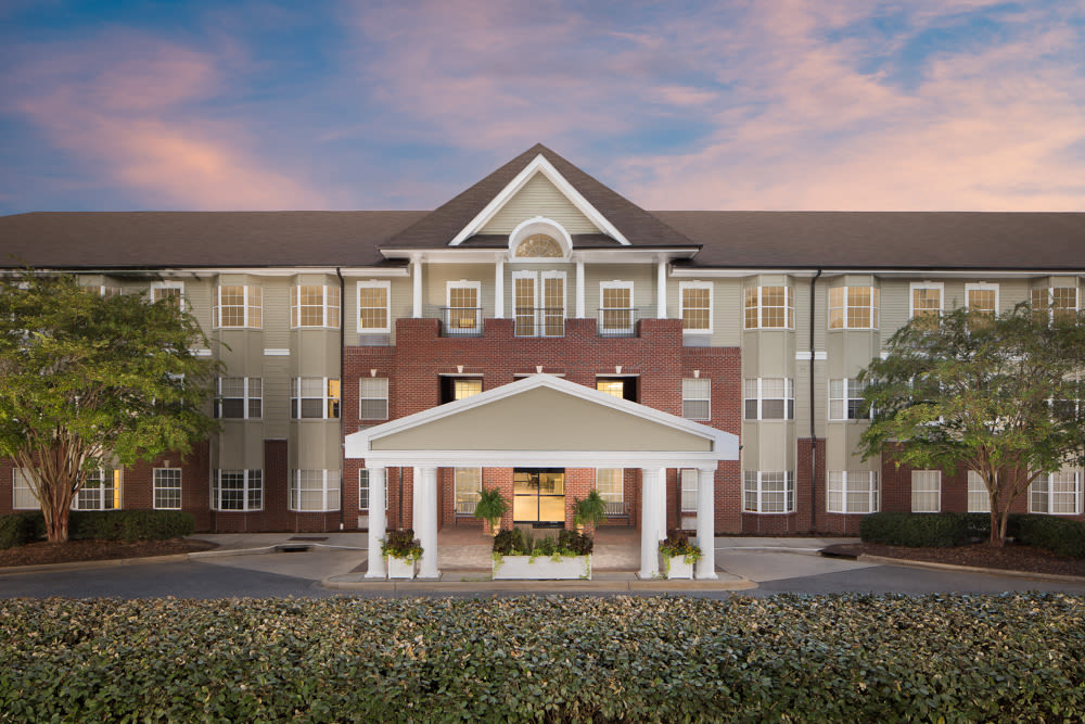 A frontal view of a residential building with a prominent entrance and landscaped surroundings.
