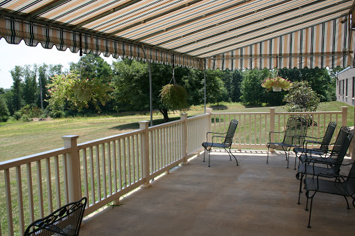 A spacious patio area with comfortable seating and a retractable awning, surrounded by lush greenery.