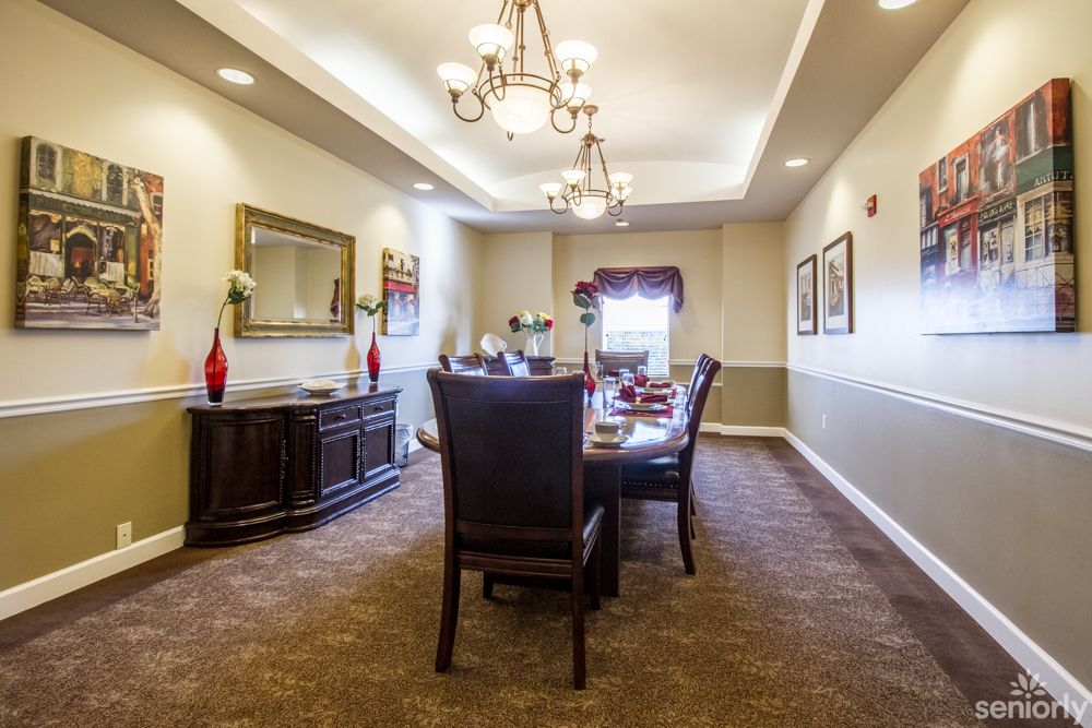 A beautifully designed dining room with a central table and elegant lighting.