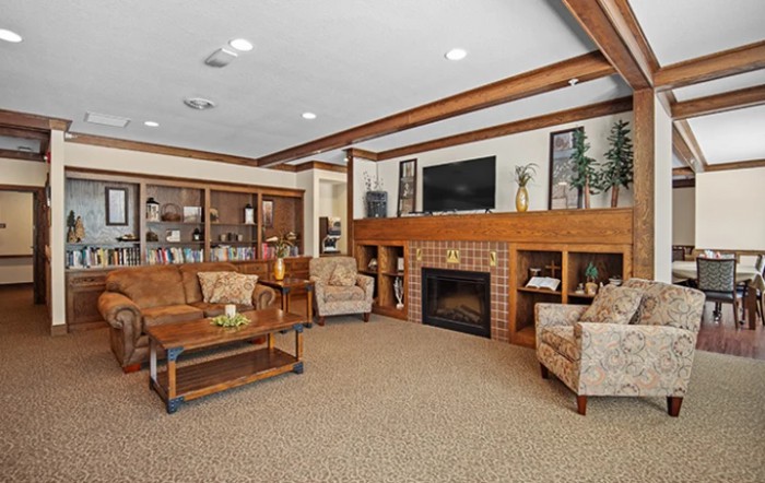 A cozy living room featuring a fireplace, television, and comfortable seating with wooden accents.