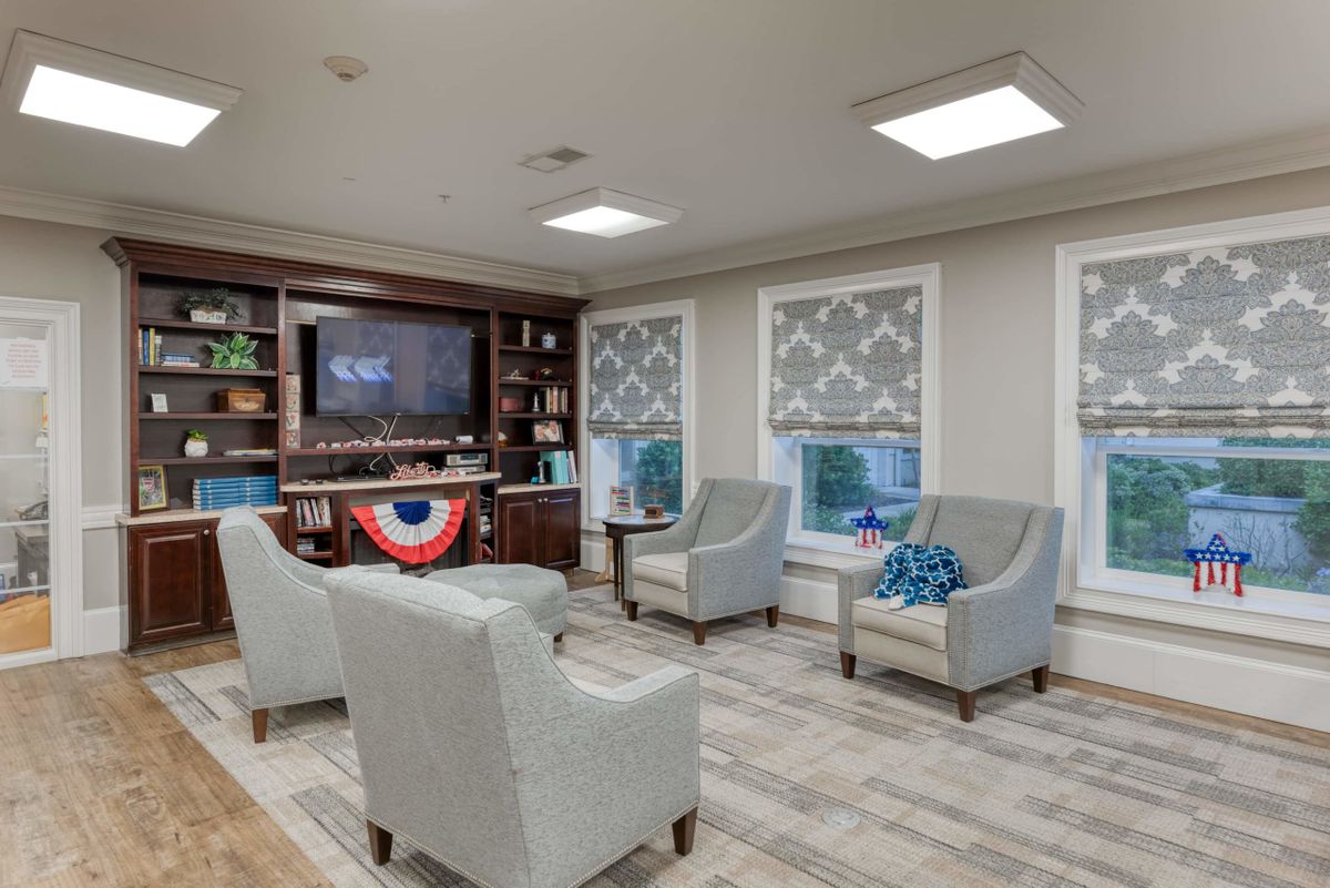 A cozy living room with armchairs, a TV, and decorative accents.