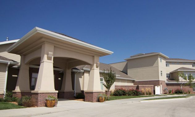 A modern building with a prominent entrance under a clear blue sky.