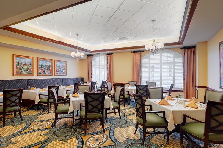 An elegant indoor dining room setup with neatly arranged tables and chairs.