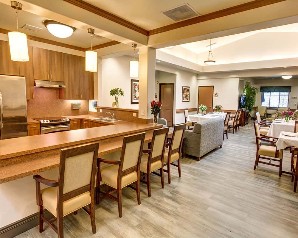 A modern kitchen and dining area with wooden furniture and bright lighting.