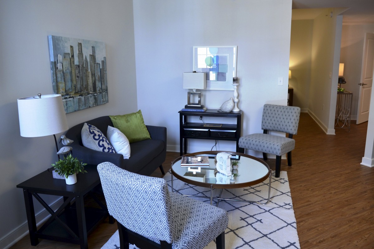 A cozy and stylish living room with a sofa, chairs, and a coffee table, complemented by modern artwork and decor.