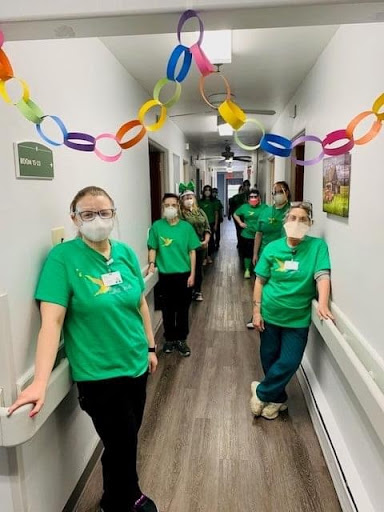 Healthcare staff posing in a decorated hallway.