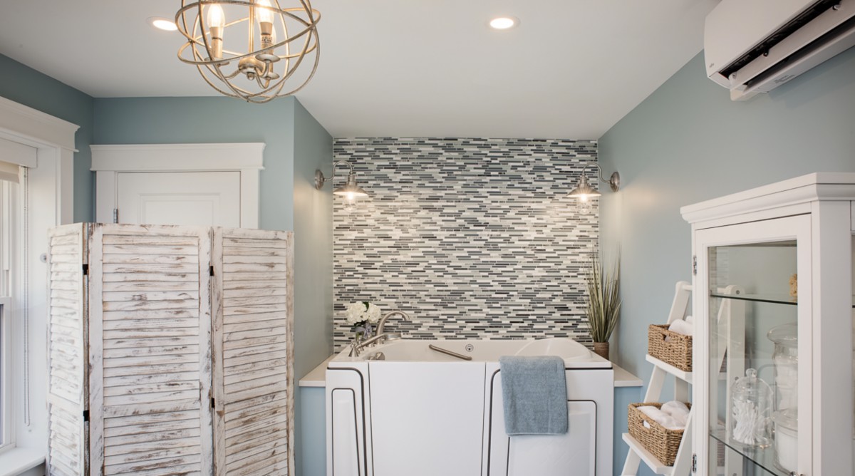 A modern bathroom with a stylish tile backsplash and freestanding bathtub.