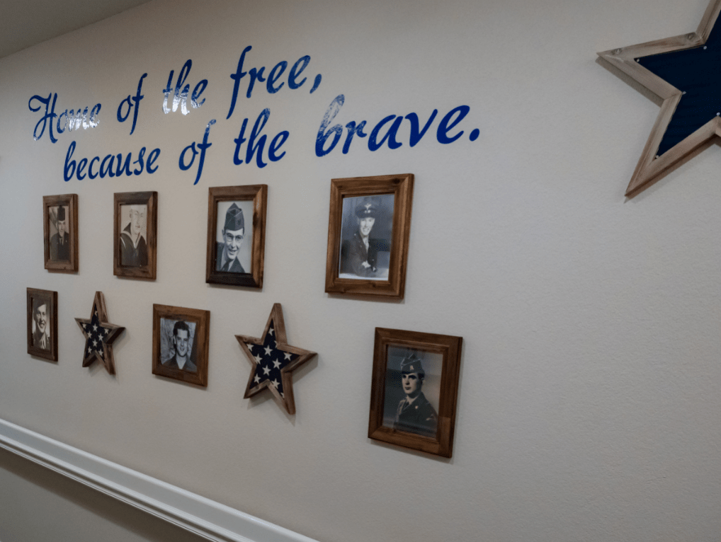 A wall decorated with military photos and a patriotic quote.