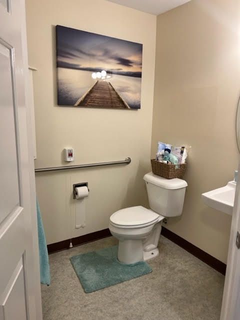 A well-organized bathroom with artwork and essentials neatly arranged.