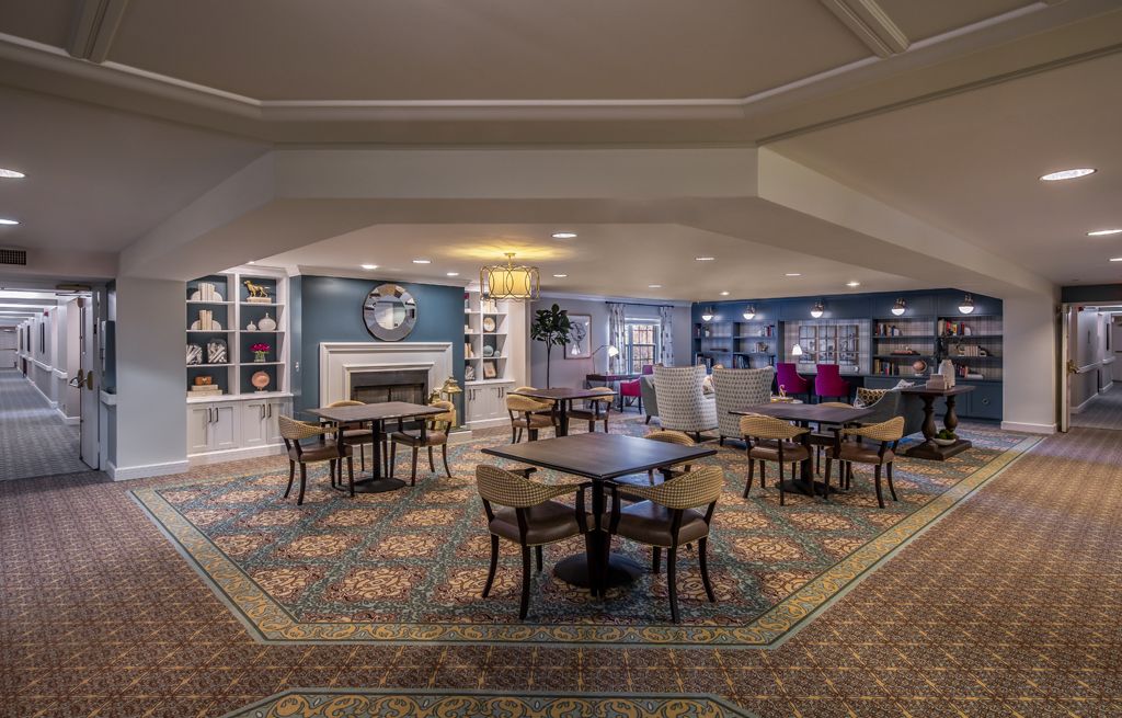 A cozy lounge area with seating, tables, and a fireplace.