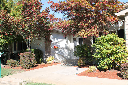A charming residential home with well-maintained landscaping and vibrant trees.