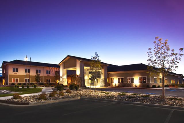 A well-lit hotel building under a twilight sky.