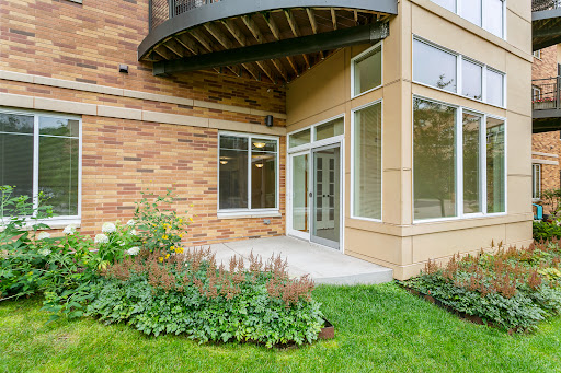 A modern building entrance with large windows and well-maintained landscaping.