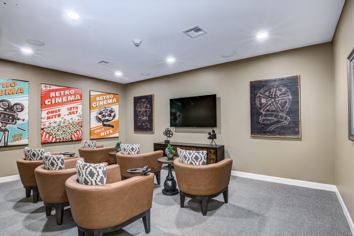 A cozy home theater room with comfortable seating and decorative posters on the walls.