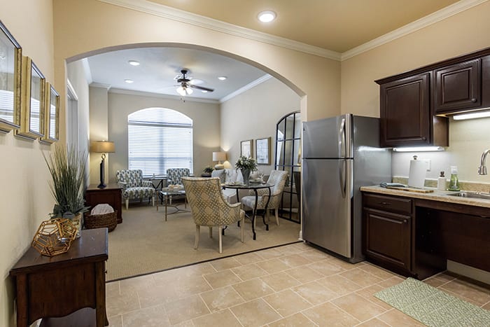 A modern open floor plan featuring a kitchen leading into a well-lit living and dining area.