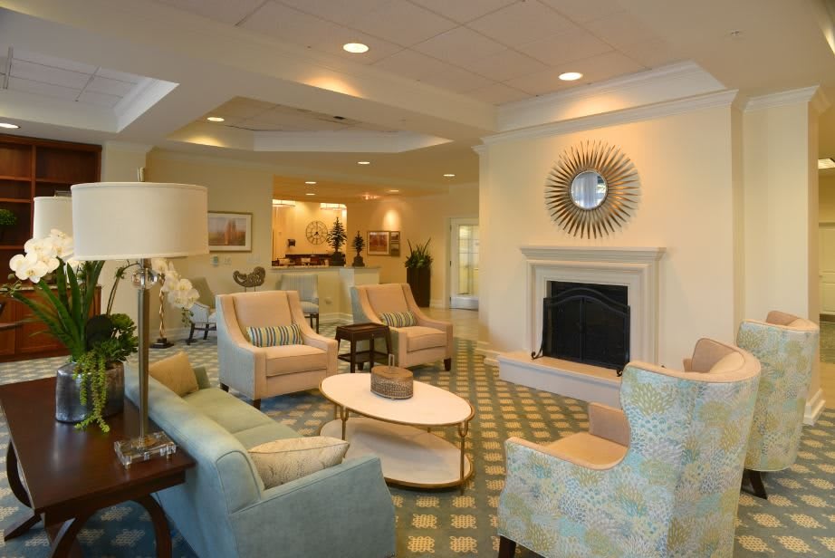 A cozy and elegantly designed living room with modern furniture and a central fireplace.